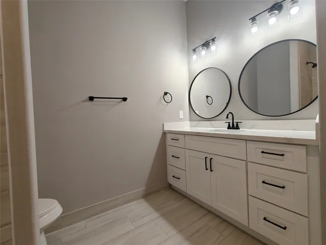 a bathroom with a toilet sink and mirror