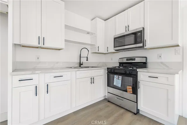 a kitchen with white cabinets and white appliances