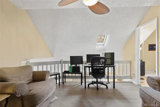 a view of a workspace with furniture and wooden floor