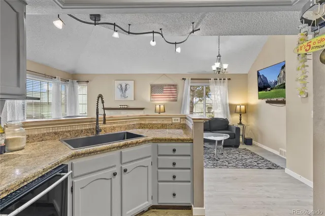 a kitchen with a sink cabinets and wooden floor