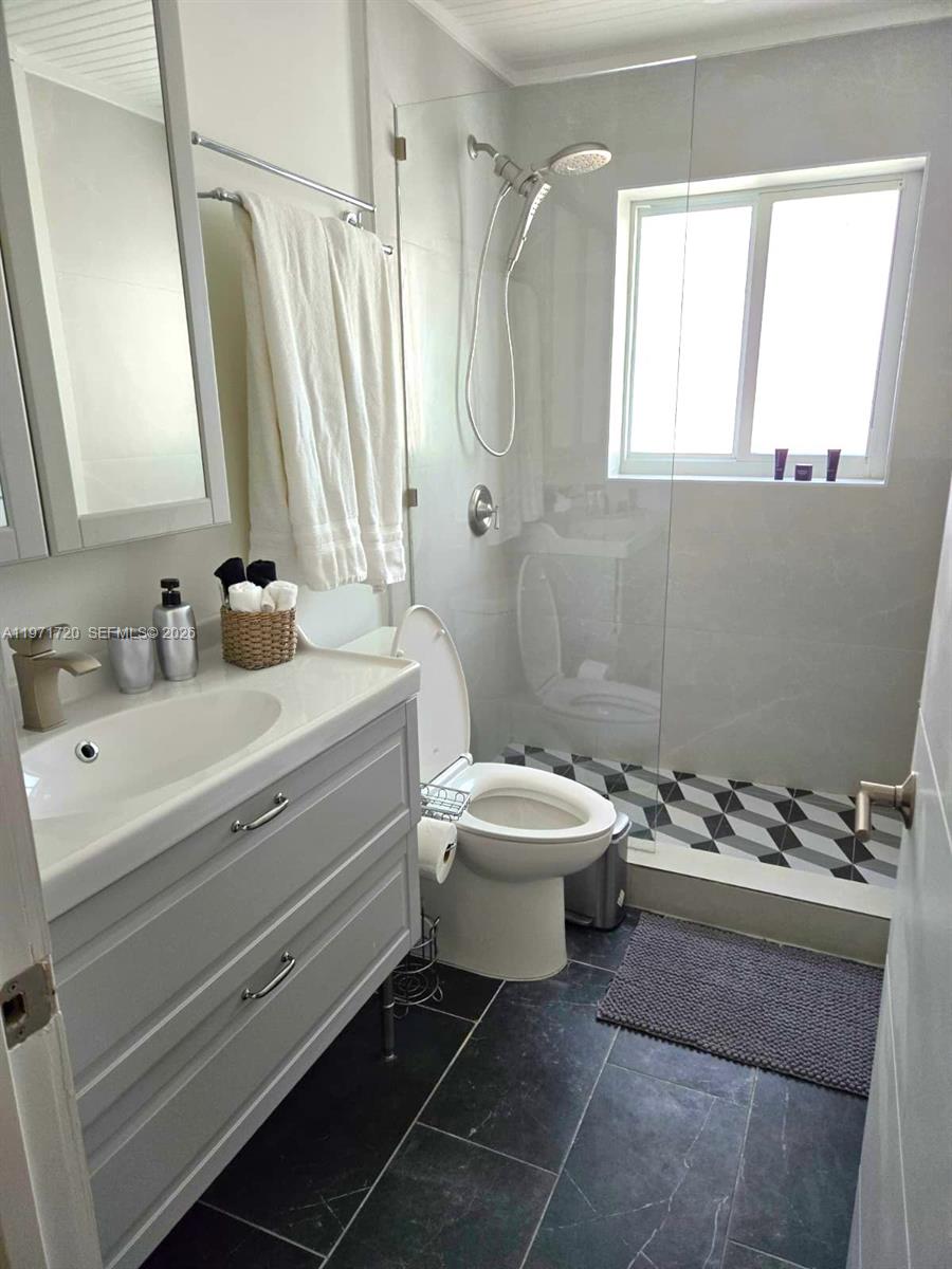 2770 Northeast 30th Street Lighthouse Point, FL 33064 - Photo 13 of 27 a bathroom with a sink a toilet and a mirror
