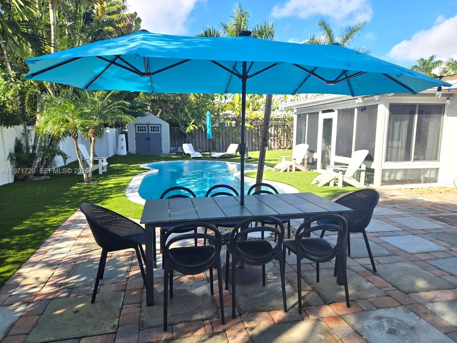 2770 Northeast 30th Street Lighthouse Point, FL 33064 - Photo 25 of 27 a view of a swimming pool with a table and chairs under an umbrella