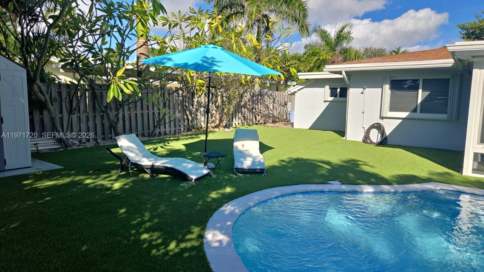 2770 Northeast 30th Street Lighthouse Point, FL 33064 - Photo 26 of 27 a view of a backyard with table and chairs under an umbrella