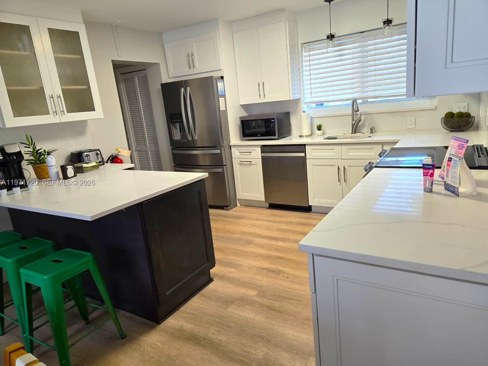 2770 Northeast 30th Street Lighthouse Point, FL 33064 - Photo 8 of 27 a kitchen with a sink refrigerator and cabinets