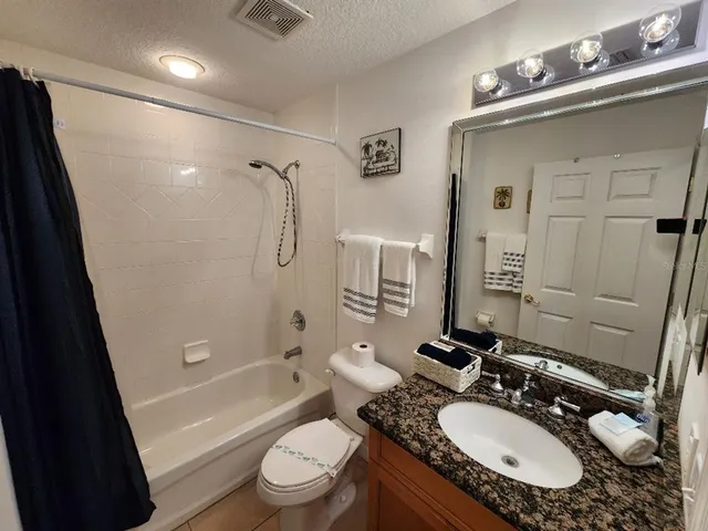 a bathroom with a granite countertop sink toilet tub and shower