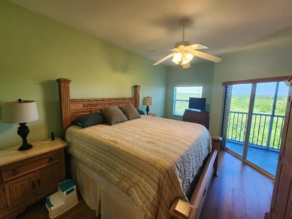 a bedroom with a bed and a lamp on dresser