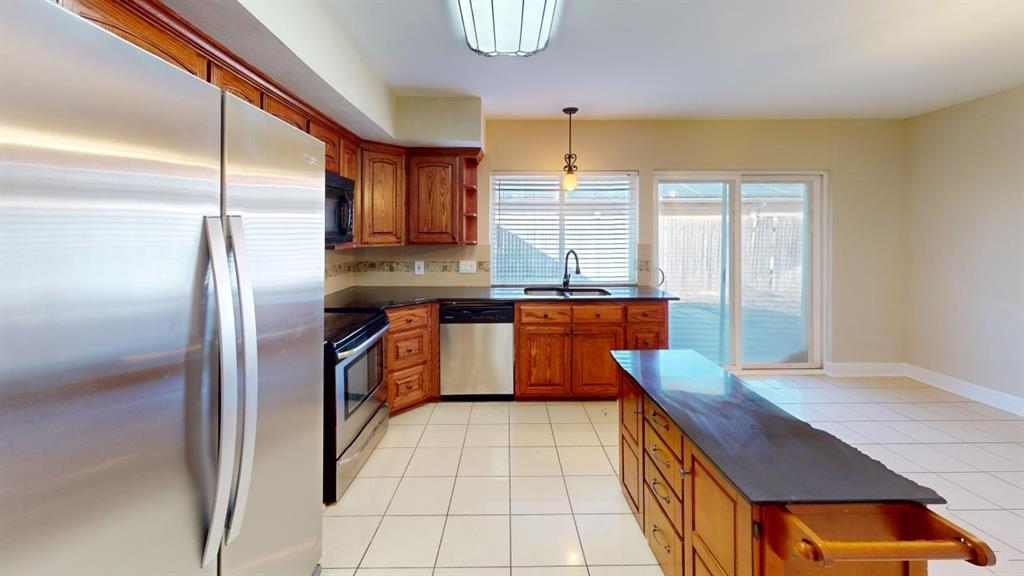 3005 Meandering Way Bedford, TX 76021 - Photo 5 of 22 a kitchen with stainless steel appliances granite countertop a sink a stove and a refrigerator