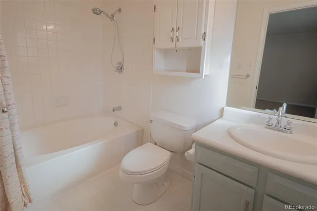 a bathroom with a toilet a sink a mirror and bathtub