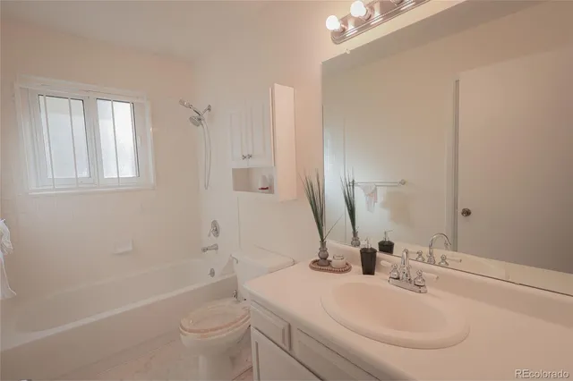 a bathroom with a sink toilet vanity and shower