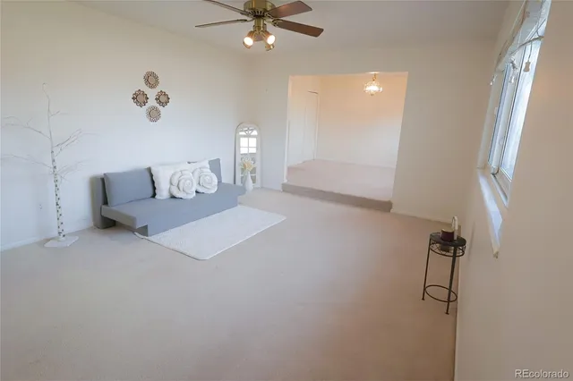 a living room with furniture and a ceiling fan
