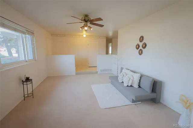a living room with couch and ceiling fan