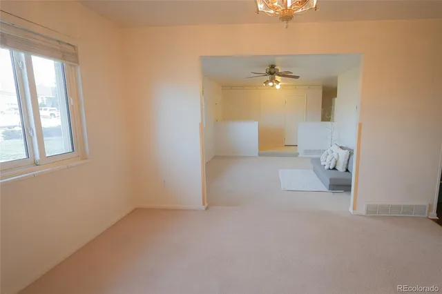 a view of a livingroom with a ceiling fan and window