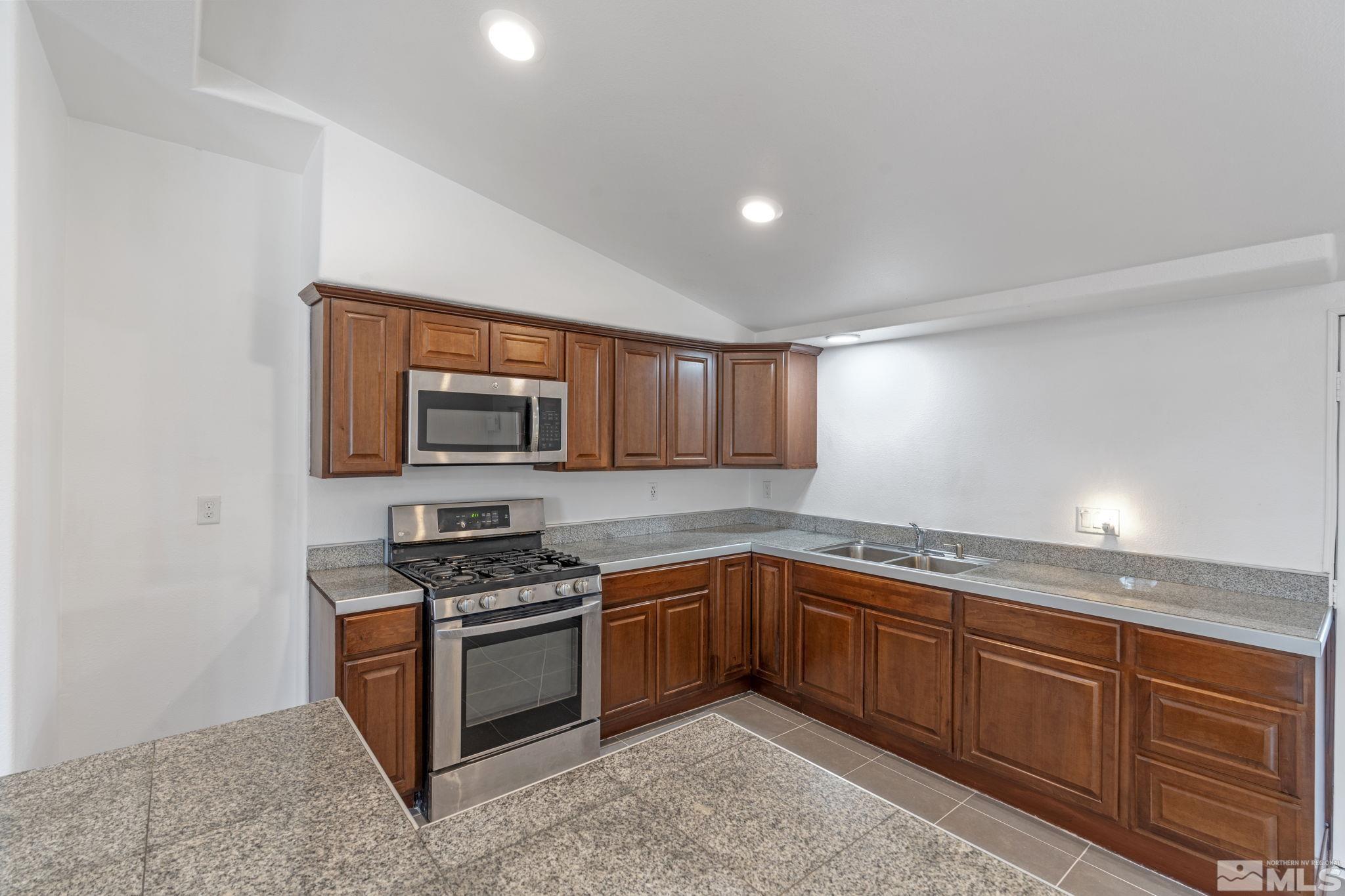 320 M Street Sparks, NV 89431 - Photo 15 of 32 a kitchen with stainless steel appliances granite countertop a stove a sink and a microwave