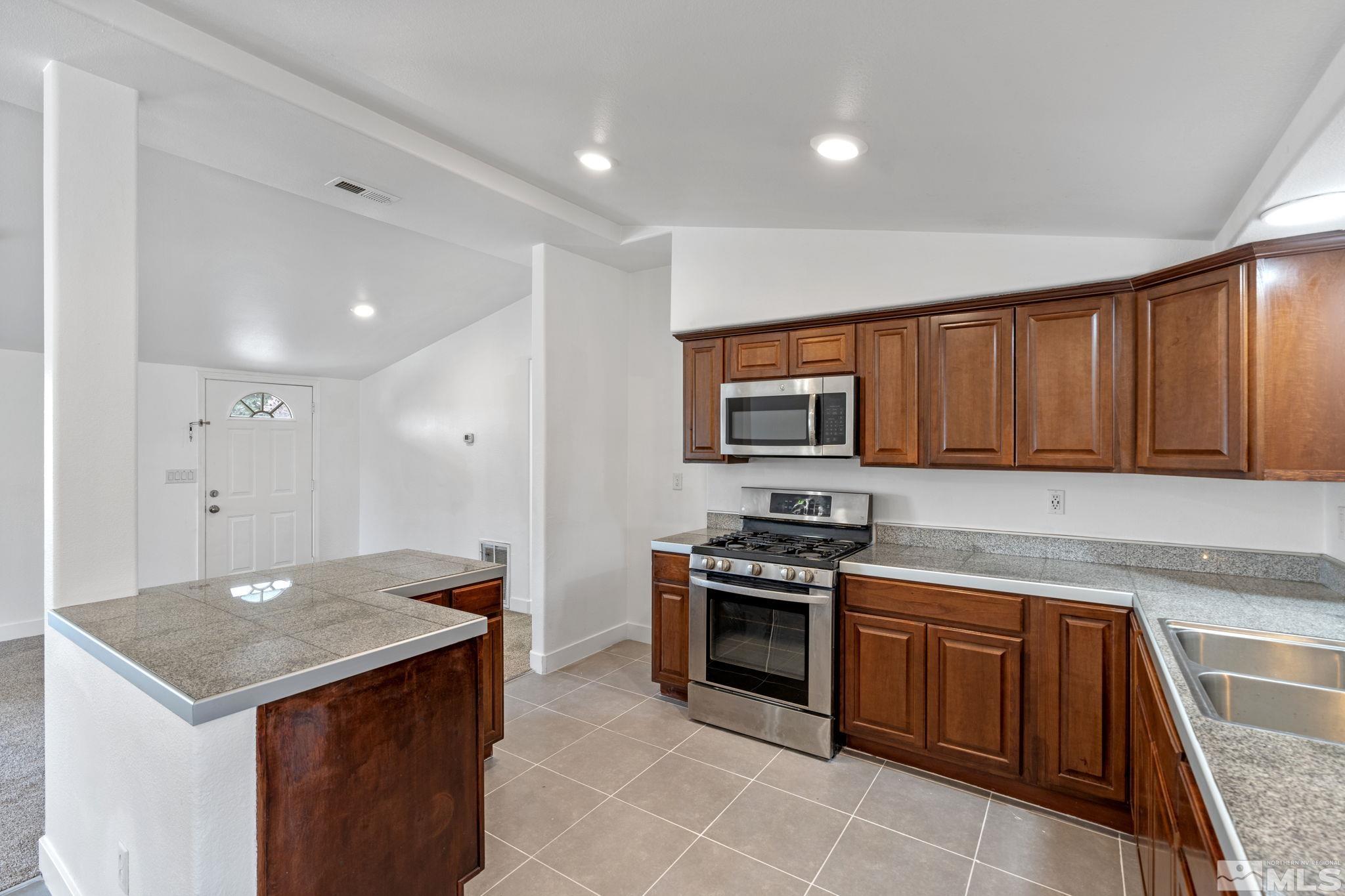 320 M Street Sparks, NV 89431 - Photo 16 of 32 a kitchen with stainless steel appliances granite countertop a stove a sink and a refrigerator