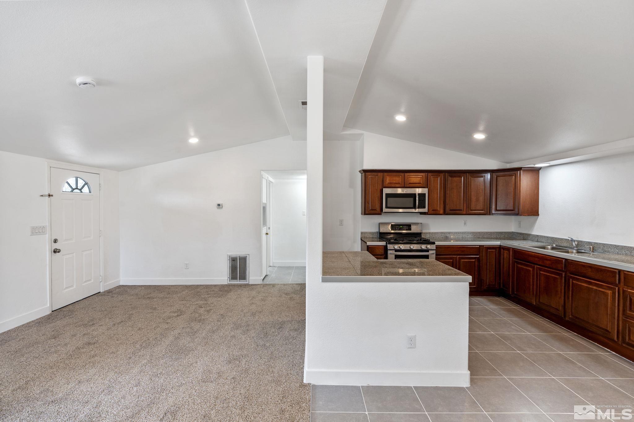 320 M Street Sparks, NV 89431 - Photo 9 of 32 a kitchen with stainless steel appliances granite countertop a stove top oven a sink a refrigerator and white cabinets