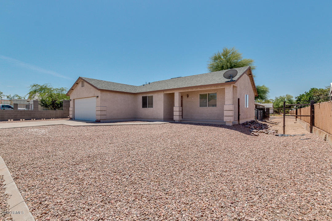 144 North Signal Butte Road Apache Junction, AZ 85120 - Photo 2 of 32 a view of a house with a yard and a garage