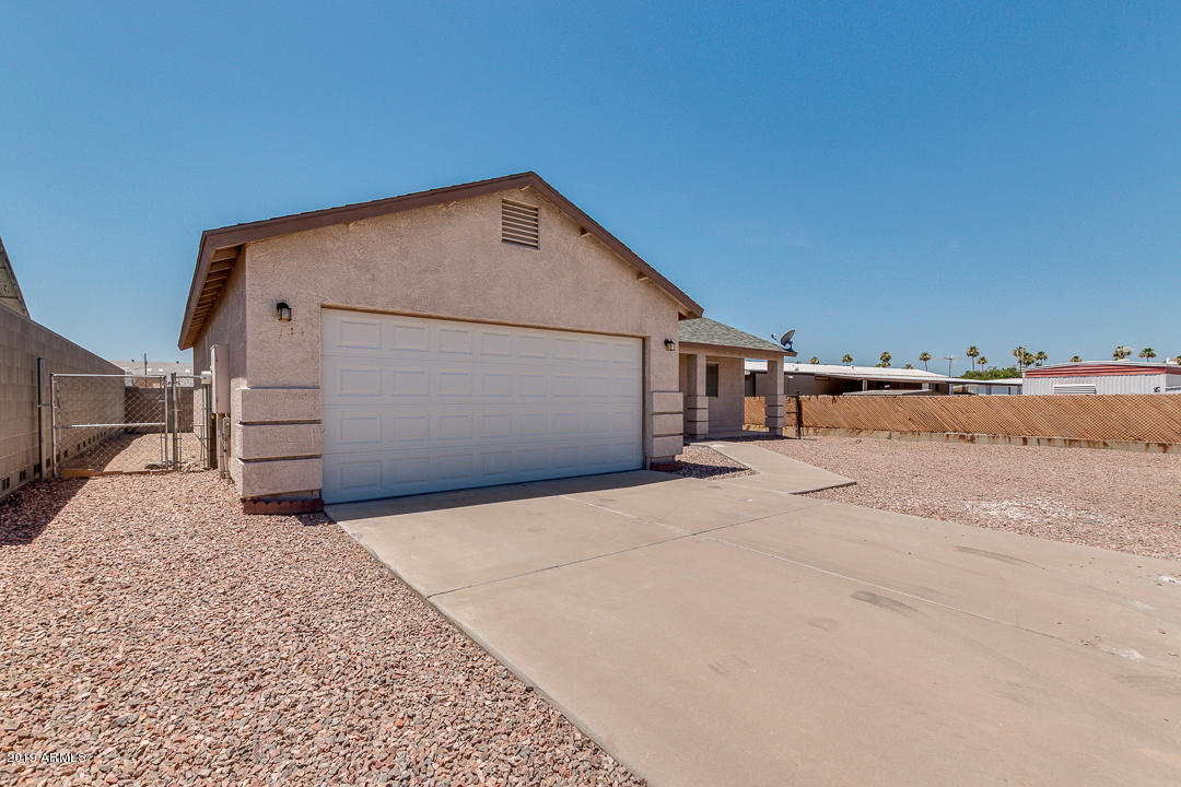 144 North Signal Butte Road Apache Junction, AZ 85120 - Photo 4 of 32 a backyard of a house with garage