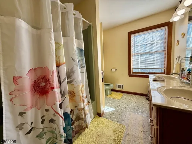 a bathroom with a granite countertop sink a mirror and shower