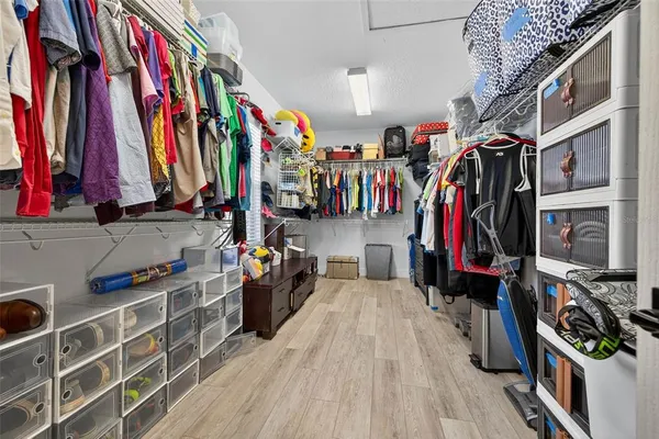 a view of walk in closet with clothes and shoes