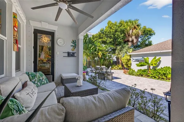 a living room with patio furniture and a potted plant