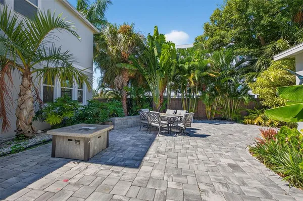 a view of a patio with table and chairs potted plants and palm trees