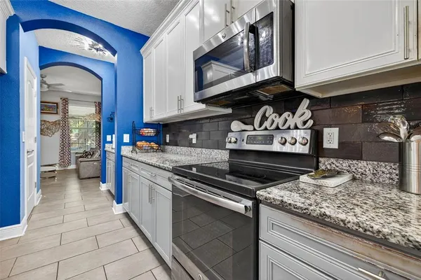 a kitchen with stainless steel appliances granite countertop a stove and cabinets