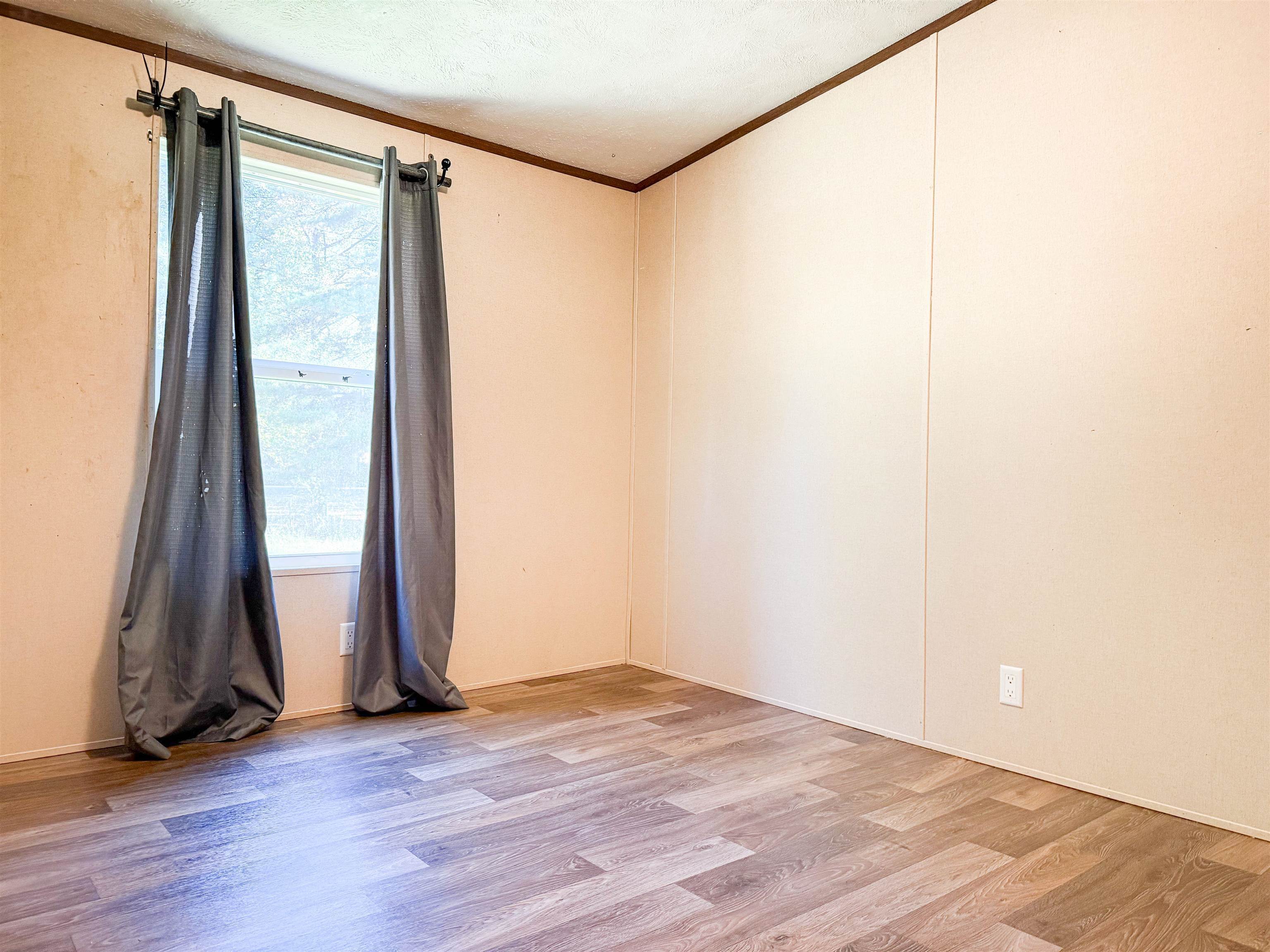 279 Travis Road Brewton, AL 36426 - Photo 8 of 17 Unfurnished room with ornamental molding and light wood-style flooring