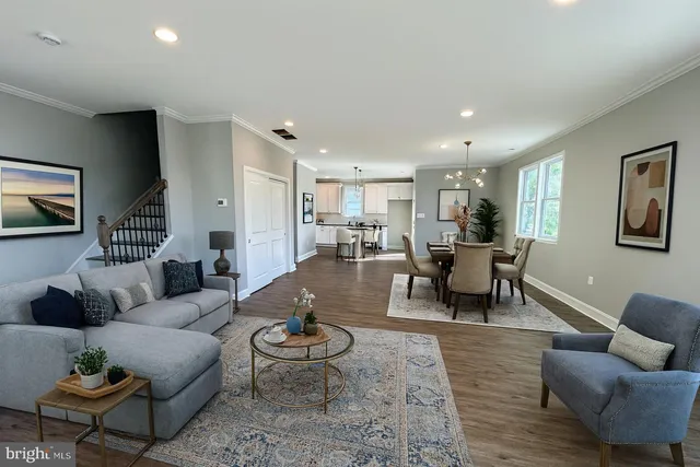 a living room with furniture and a view of kitchen