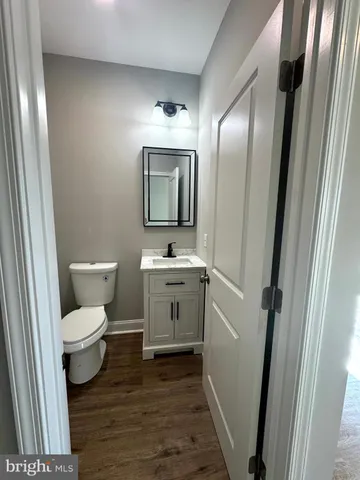 a bathroom with a sink a toilet a mirror and shower