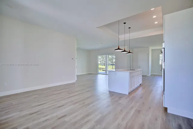a view of a kitchen with wooden floor and a ceiling fan