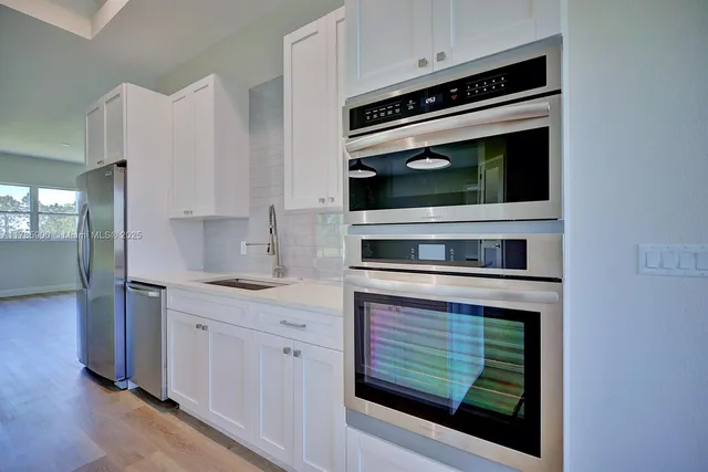 a kitchen with stainless steel appliances granite countertop a stove and a microwave