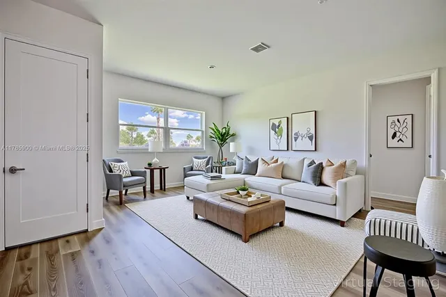 a living room with furniture and a wooden floor