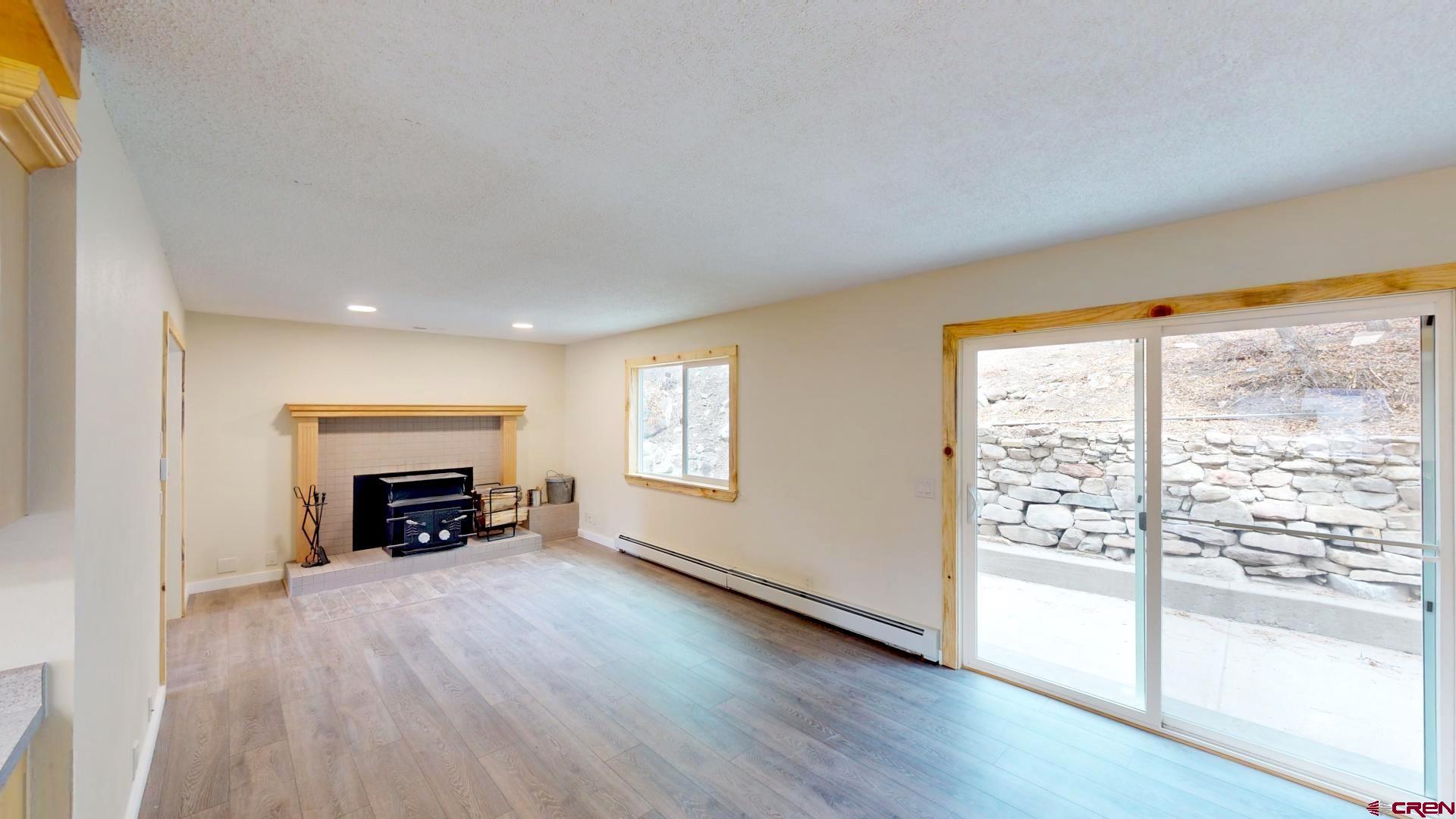 356 County Road 201 Durango, CO 81301 - Photo 11 of 35 an empty room with fireplace and wooden floor