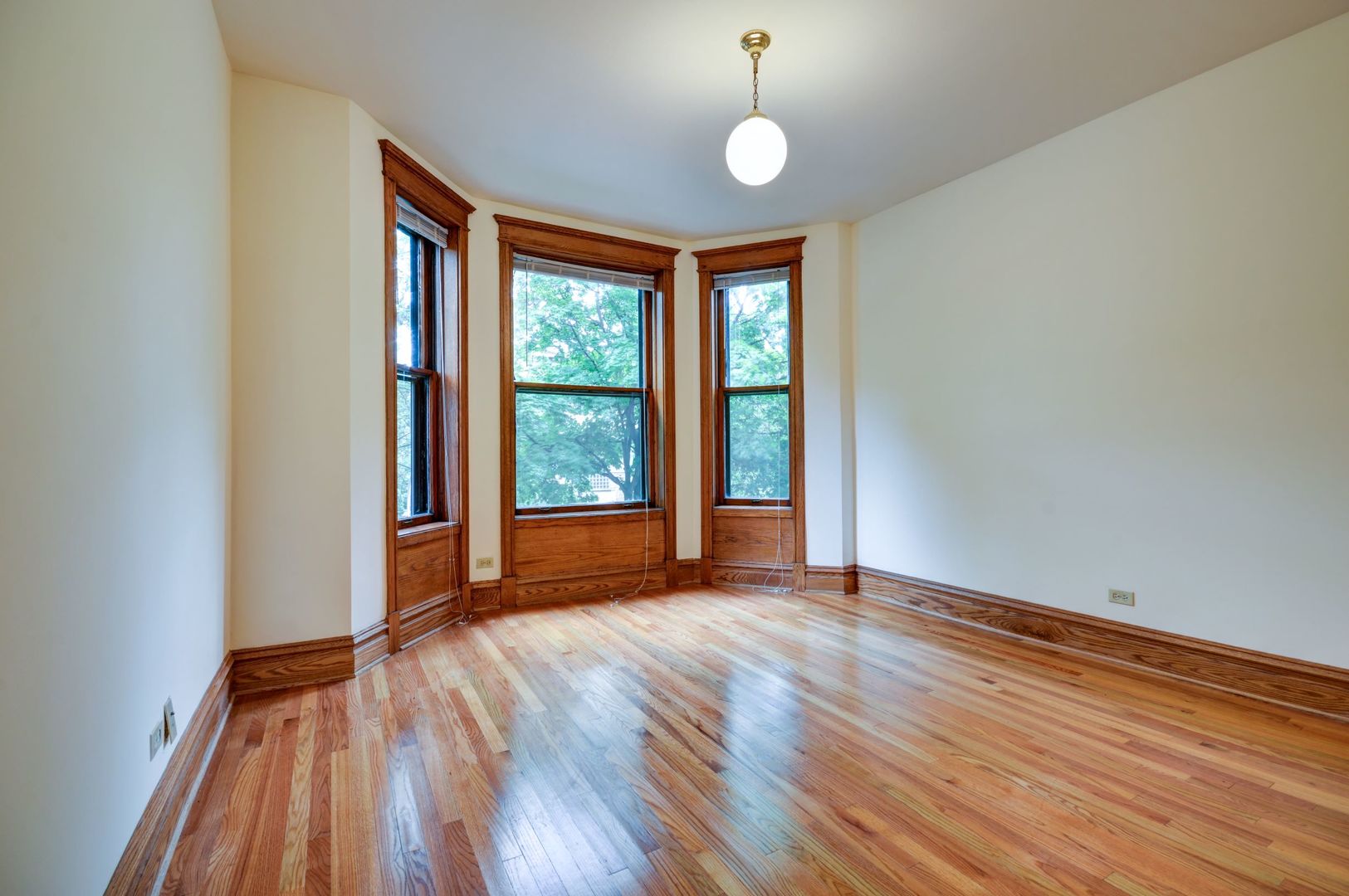 3722 North Fremont Street, Unit 2 Chicago, IL 60613 - Photo 3 of 16 a view of an empty room with wooden floor and a window