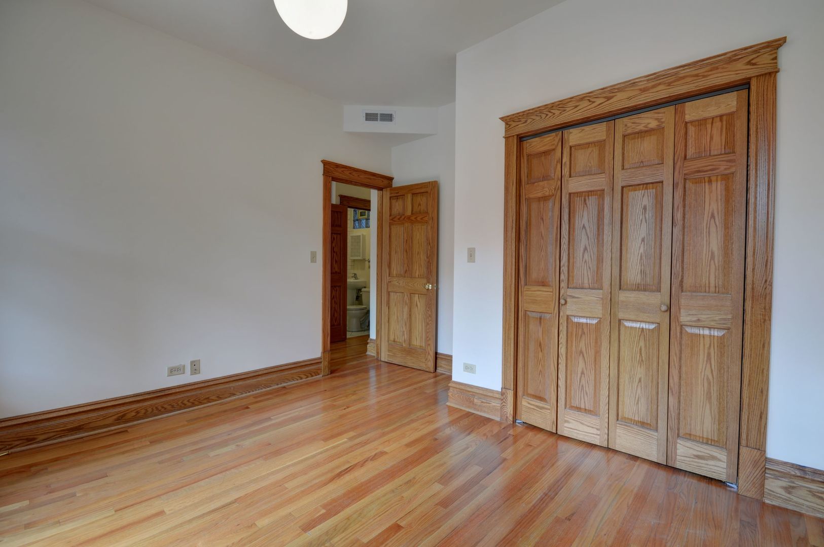 3722 North Fremont Street, Unit 2 Chicago, IL 60613 - Photo 7 of 16 an empty room with wooden floor and closet