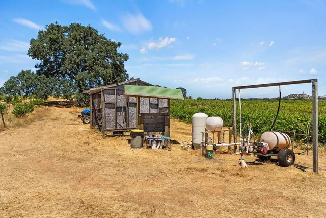 a view of a backyard with table and chairs and couches under an umbrella