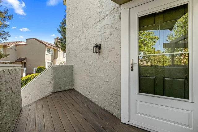 a view of a balcony with wooden floor and cabinet