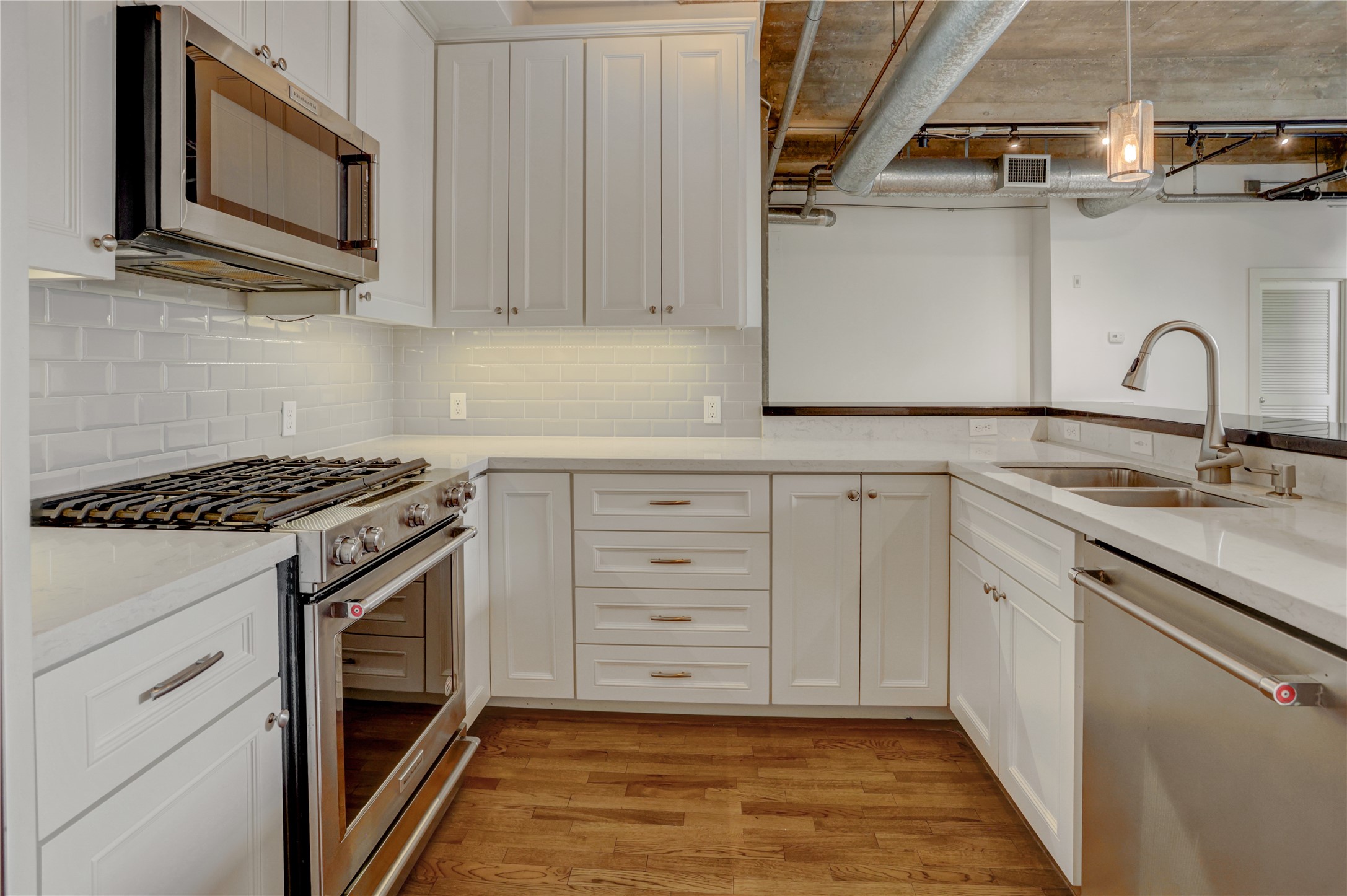 204 Travis Street, Unit 4D Houston, TX 77002 - Photo 5 of 22 a kitchen with stainless steel appliances granite countertop a stove a sink and a microwave