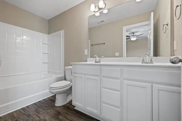 a bathroom with a sink a toilet and mirror