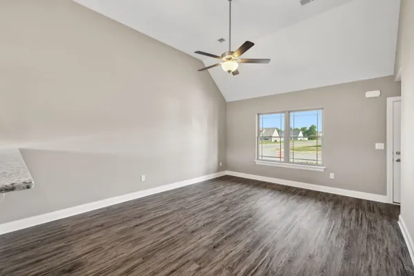 a kitchen with granite countertop a stove and a wooden floor