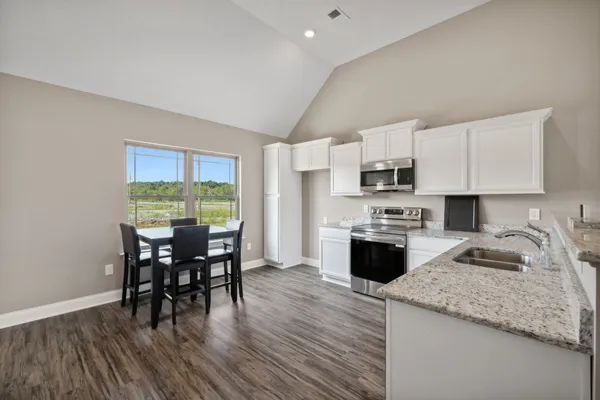 a kitchen with granite countertop a stove and a sink