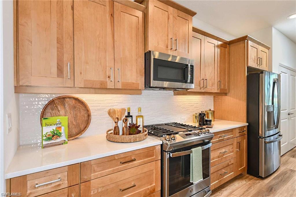 4563 Centaurus Circle Naples, FL 34120 - Photo 10 of 20 a kitchen with stainless steel appliances granite countertop a stove a sink and a refrigerator