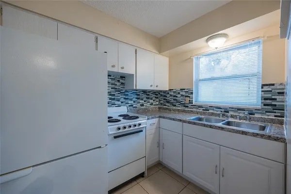 a kitchen with cabinets appliances and a window