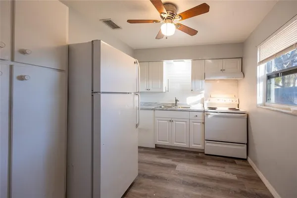 a kitchen with cabinets a refrigerator and a sink