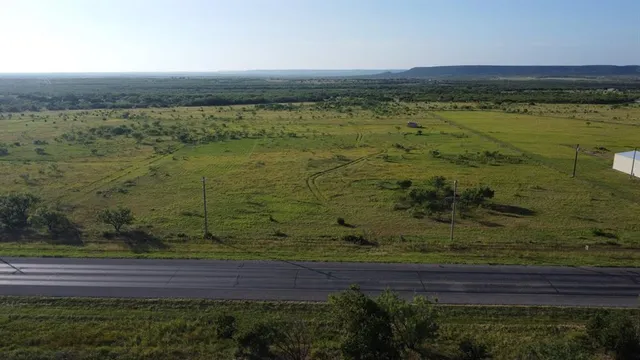 a view of a field with trees in the background
