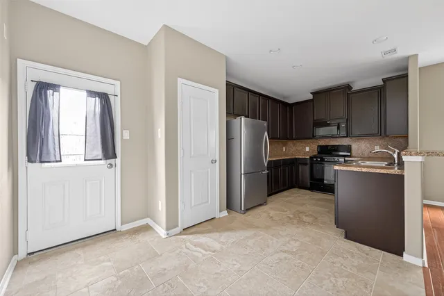 a kitchen with stainless steel appliances granite countertop a refrigerator and a sink