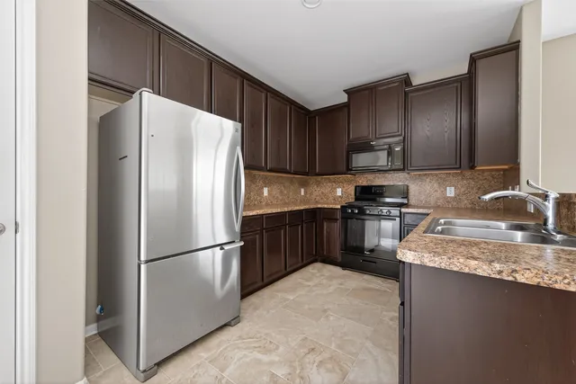 a kitchen with granite countertop a refrigerator and a sink