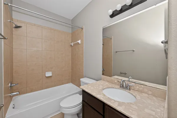 a bathroom with a granite countertop sink a toilet and shower