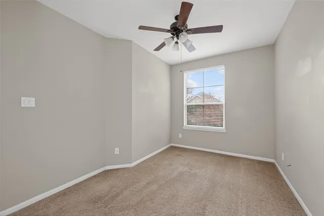 a view of room with ceiling fan and windows