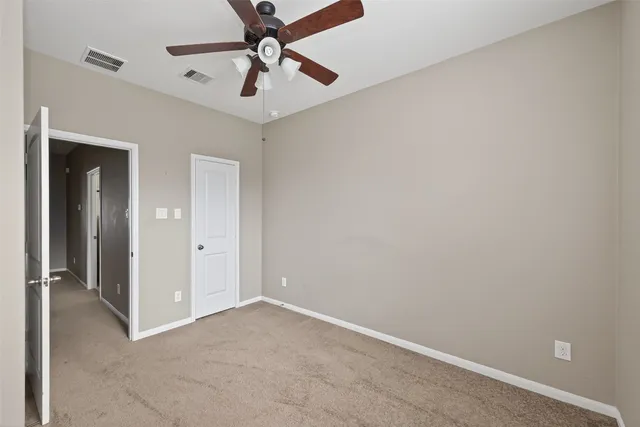 an empty room with a ceiling fan and a window